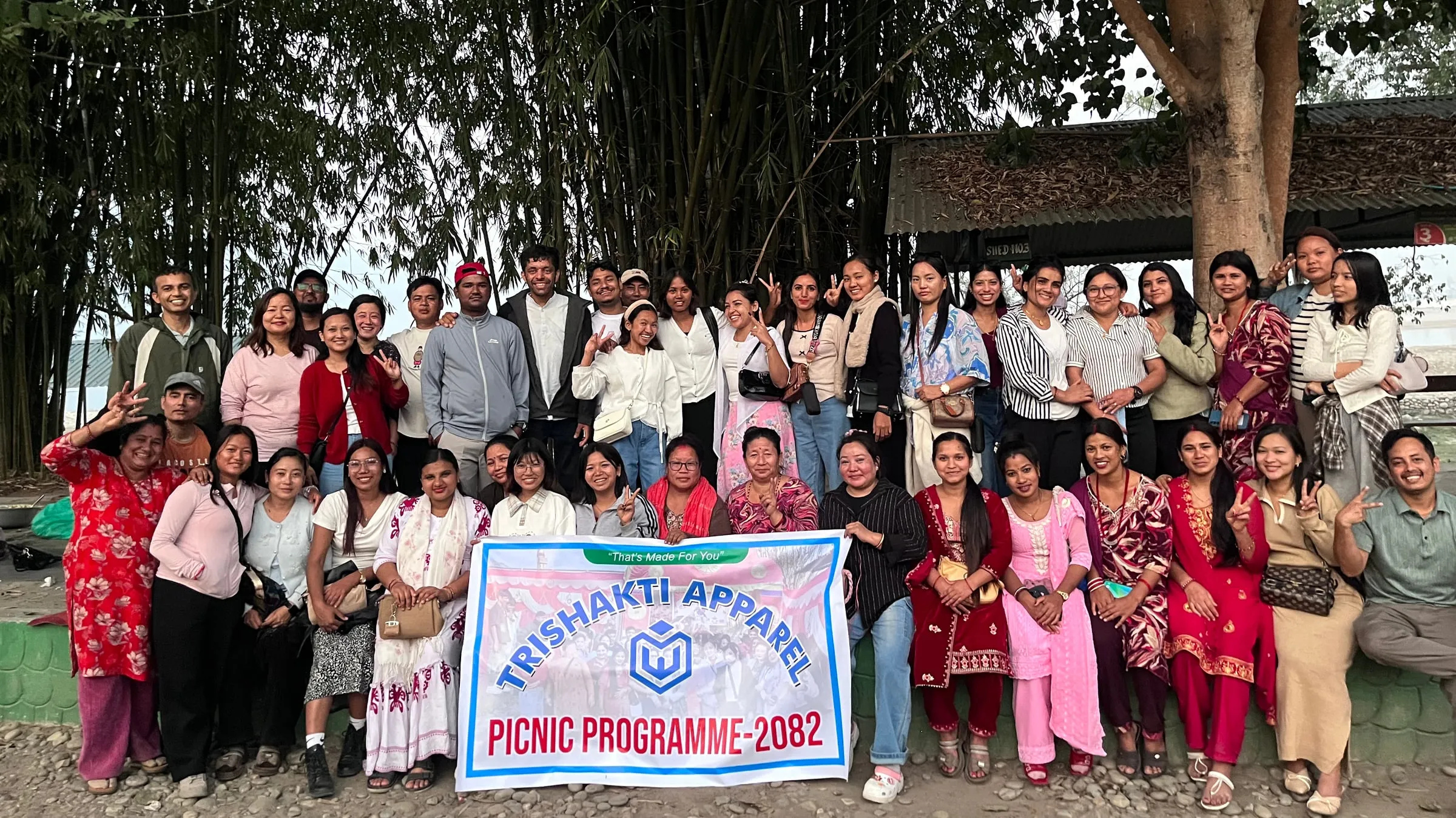 The Trishakti Apparel team at the Picnic Programme 2082, gathered behind the company banner “That’s Made For You”